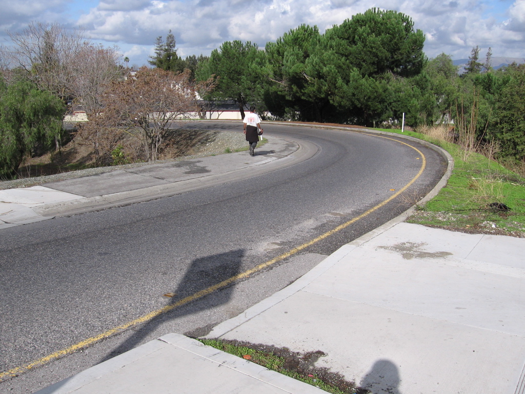 On-ramp sidewalk is a stroller, wheelchair alternative to staircase, looking downward.