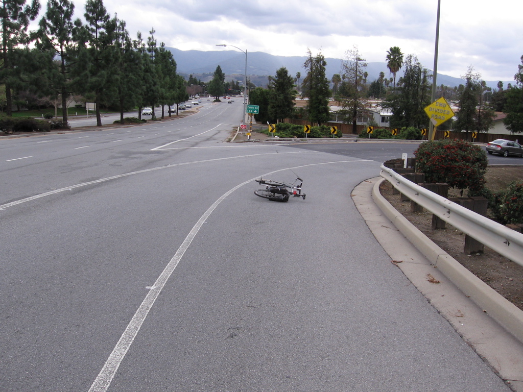 Bike shown in shoulder. Continue shoulder all the way along the right turn, to Cottle. Re-do double-turn lane for modern safer design for bicyclsts/walkers going straight through along Blossom Hill Road. (NW side)